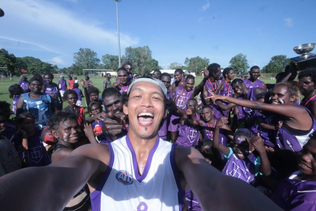 Irawan posing in front of the Tikaliru Dockers Tiwi Islands AFL Grand Final 2018